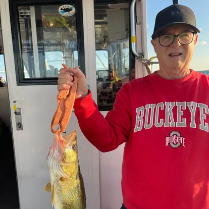 Guest holding a walleye beside the cabin
