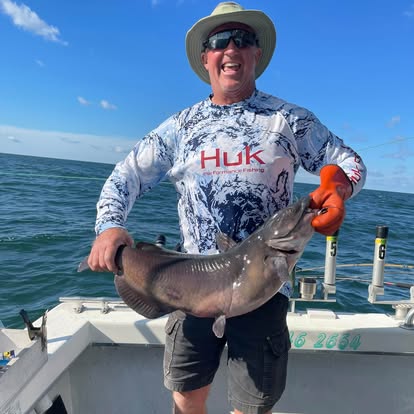 Guest holding a catfish on the boat